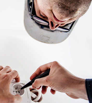 Electrician working on electrica outlet — Electrical Installations & Repairs in NSW